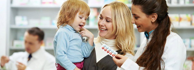pharmacist giving vitamins to child