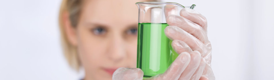 pharmacy scientist holding glass beaker with green liquid
